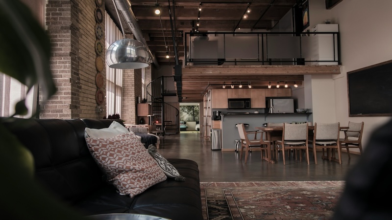 Open floor plan of living room with brick walls and concrete flooring