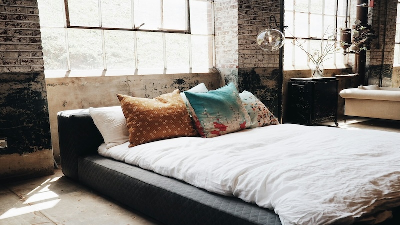 Bedroom with brick walls and a platform bed