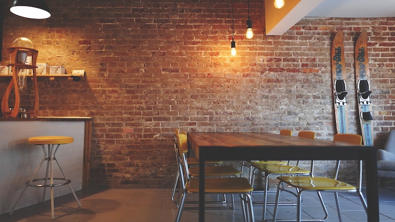 Dining room with dining table and chairs in front of a red brick wall