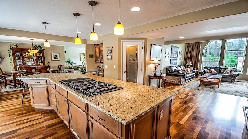 Brown kitchen island with granite countertops and wood flooring