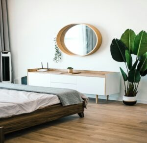 Bedroom with dresser and circle mirror above